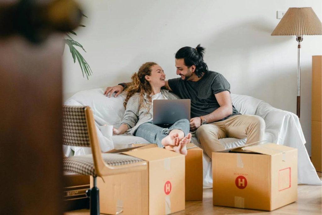 Couple researching what to do with solar panels when moving on their laptop