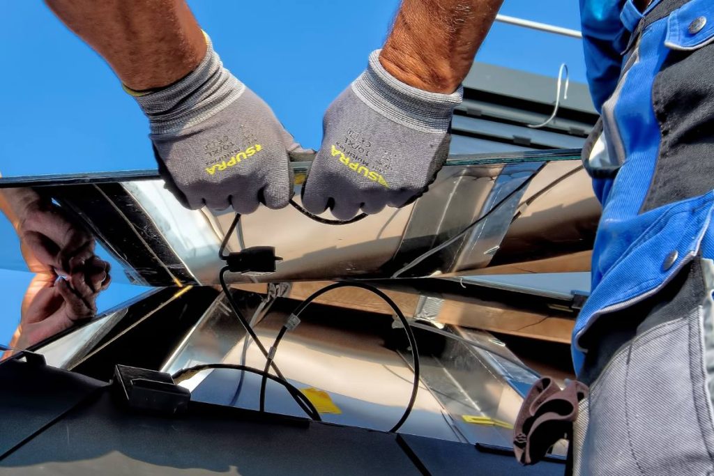 A person installing solar panels on a roof