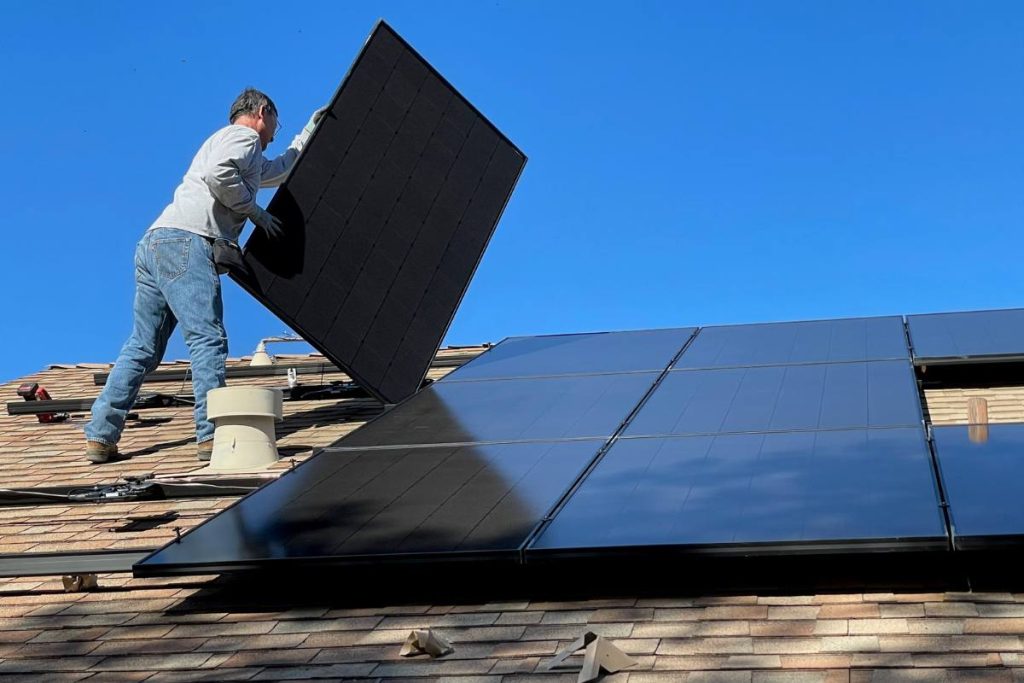 Professional removing solar panels from a roof