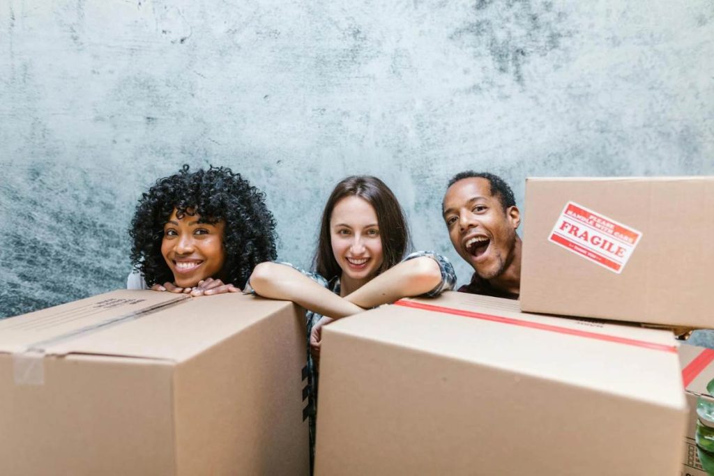 Happy people standing behind the package of boxes taking a picture